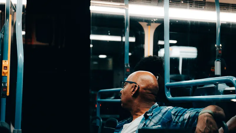 Un hombre sentado en un camión de noche, con la mirada perdida en la ventana.